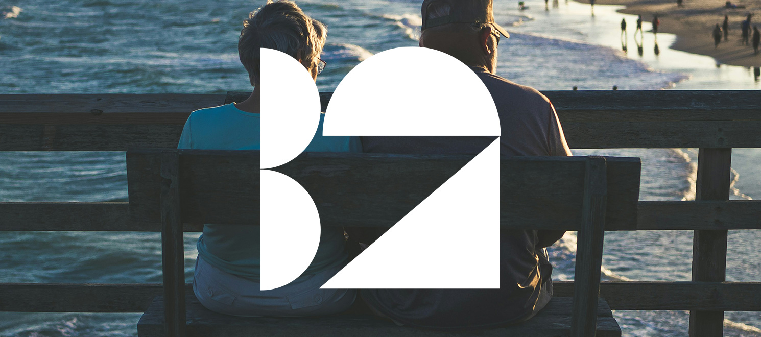Image of two people sat on a bench, depicting retired people for our branding for retirement developers blog